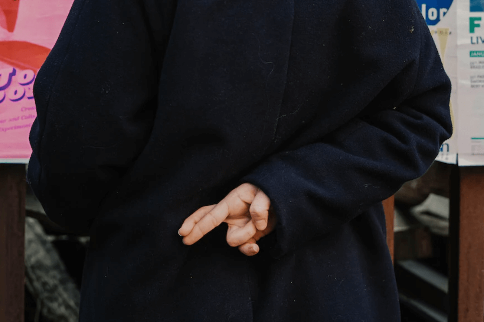 A person crossing their fingers behind their back.