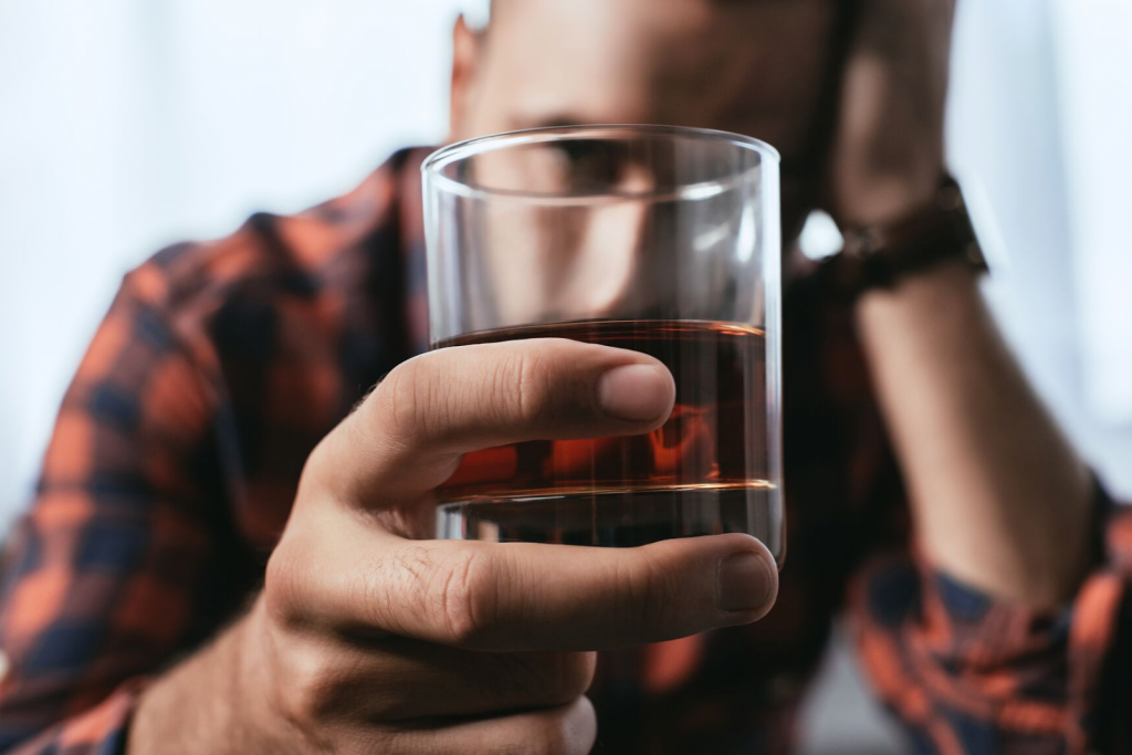 Close up of a man drinking an excessive amount of alcohol