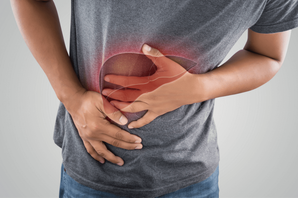 Close up of a man clutching his stomach due to liver problems