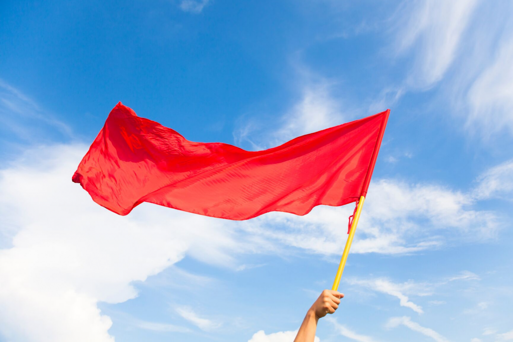 Close up of a person waving a red flag