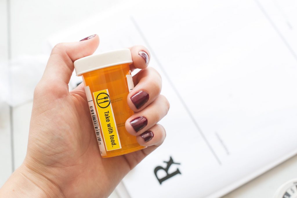 Close up of a woman holding a prescription drug bottle