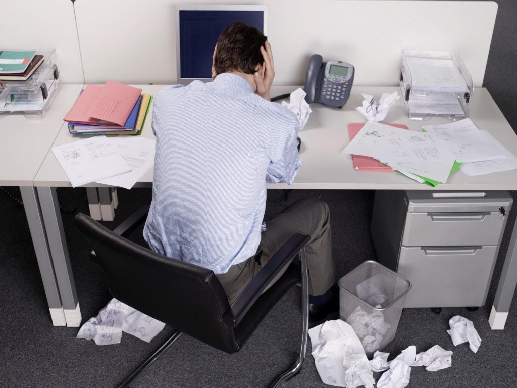 Someone at their desk in pain and unable to work