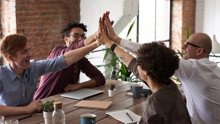 People doing a high-five at a meeting