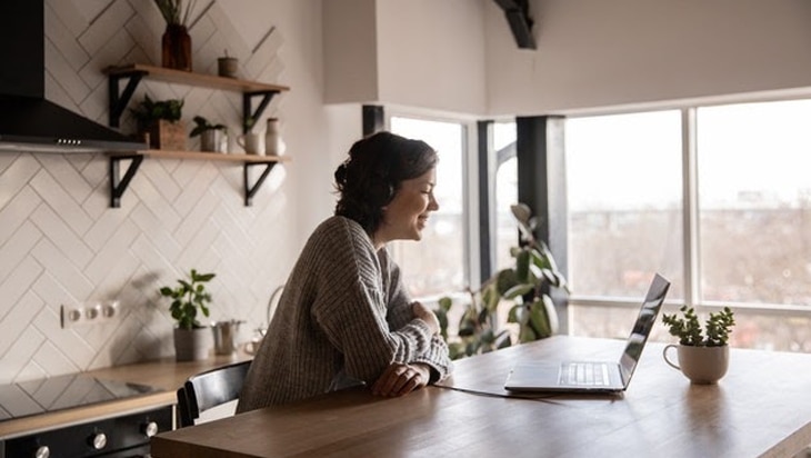 Smiling person sitting in front of her laptop