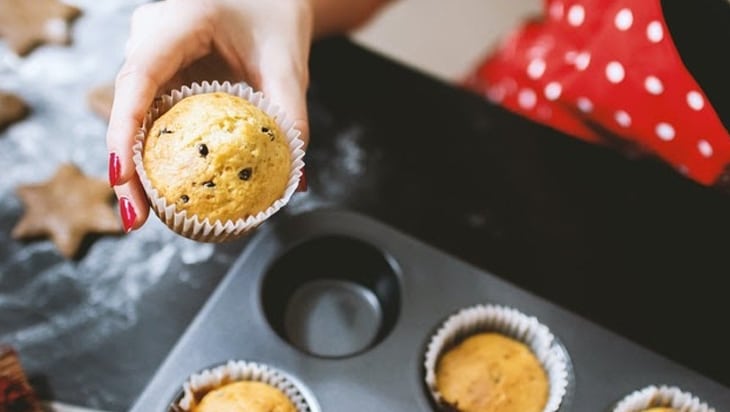 Close up shot hand holding a freshly baked cupcake