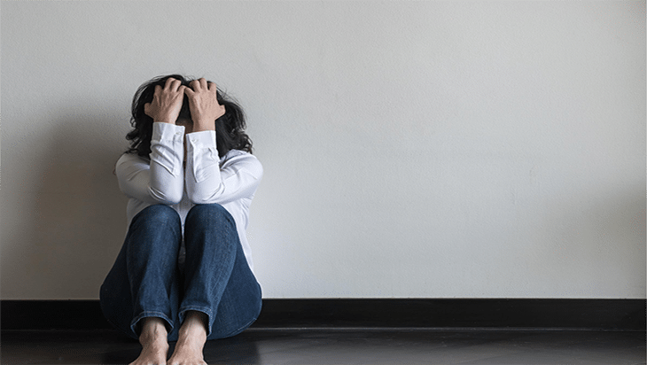 Woman sitting on the floor, distressed