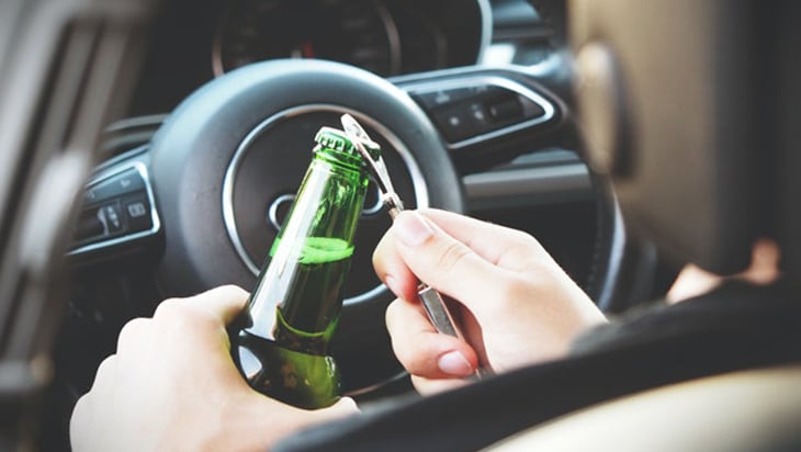 Opening a bottle of beer inside the car