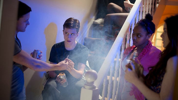 Teens at a party passing a joint around