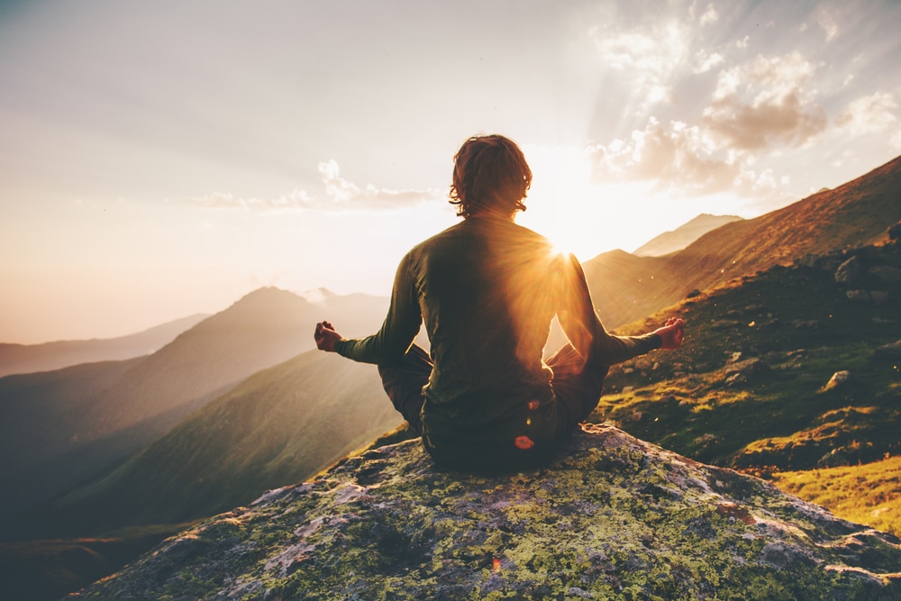 Man meditating in the mountains