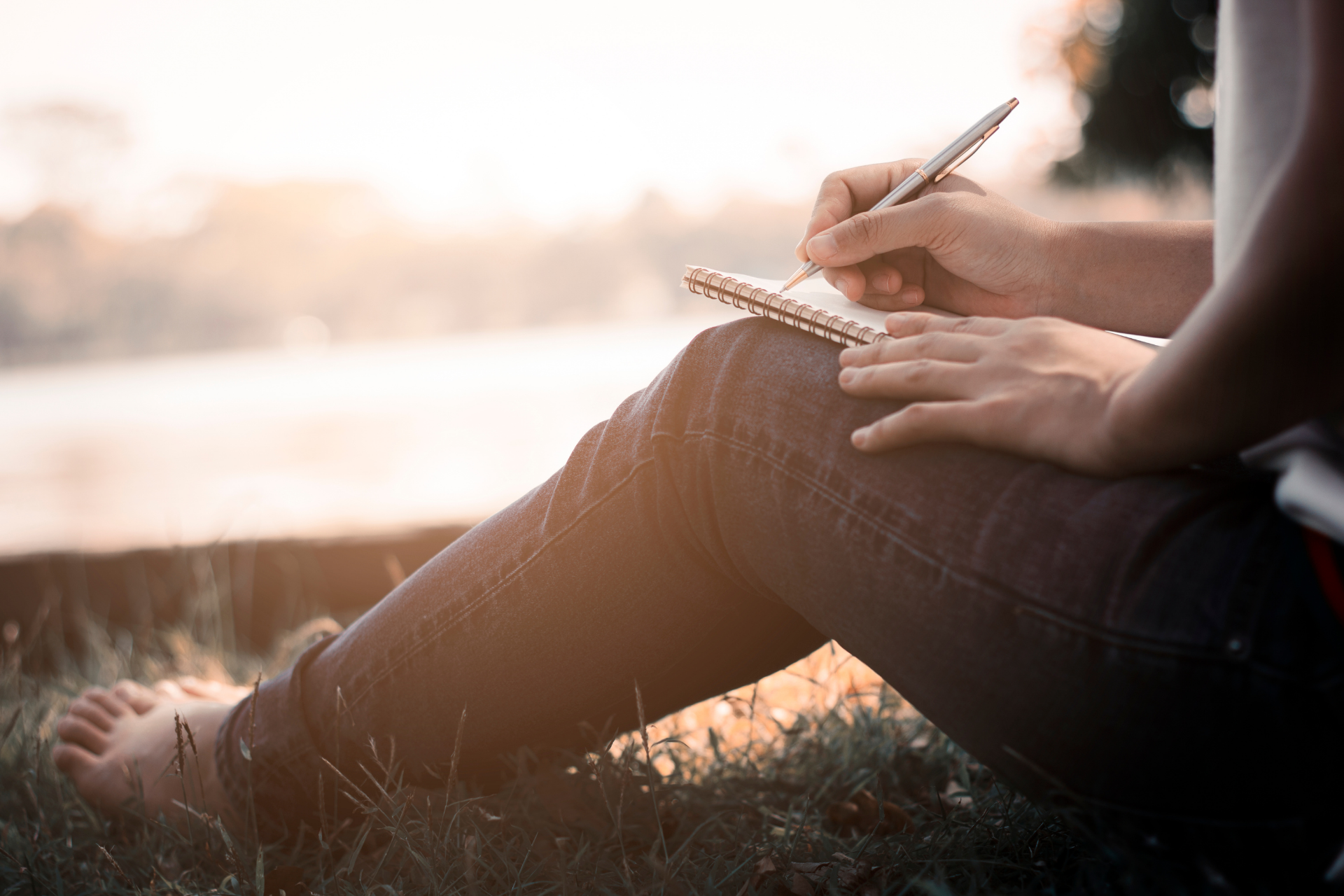 An individual writes down their addiction recovery goals with paper and pen