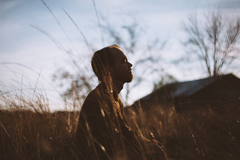  A man sitting meditating in a field 