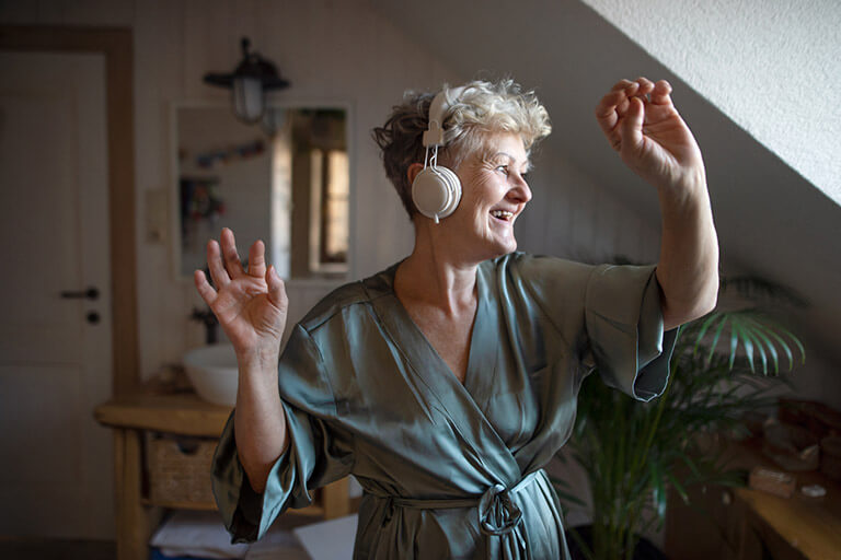  An older woman listening to music and practicing self-care