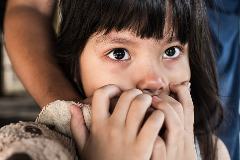 A scared young girl with a man’s hand covering her mouth