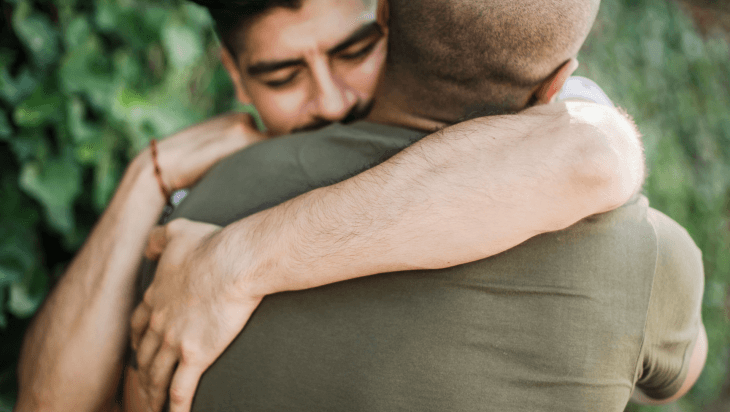 Two men hugging after an apology