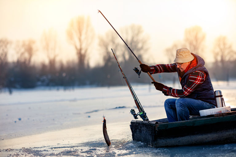 A man ice fishing in a frozen lake.