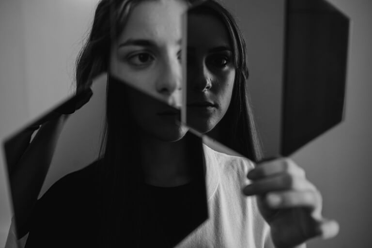 a girl looks at herself in a mirror