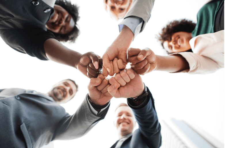 Close up of people putting their hands together