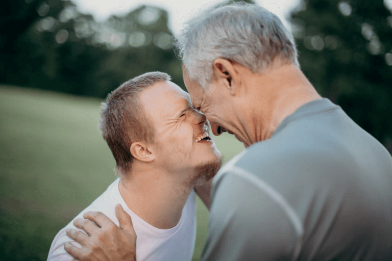 A male parent laughing with his son.