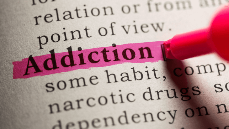 A person highlighting the word “addiction” on paper.