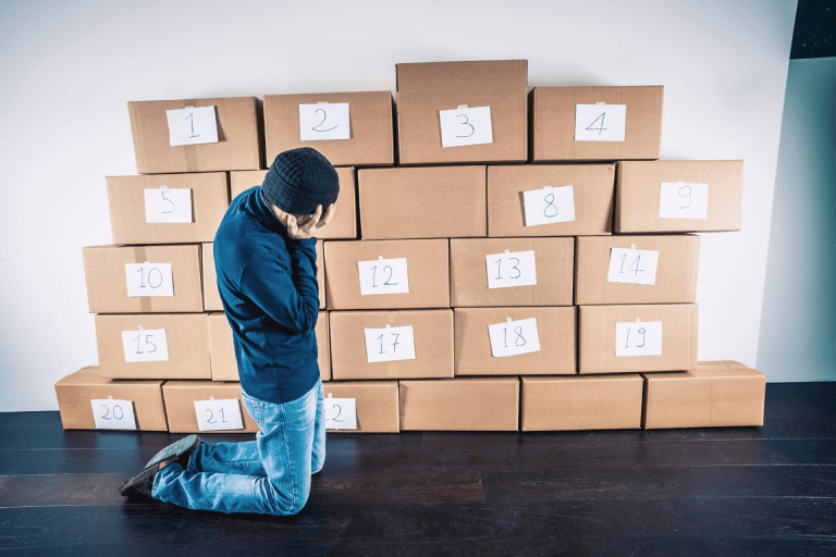 A man trying to organize numbered boxes.