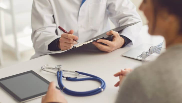 A medical professional takes notes during a consultation for opioid addiction treatment