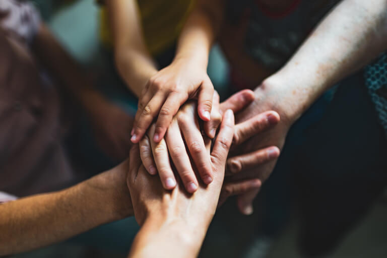 several people putting their hands together