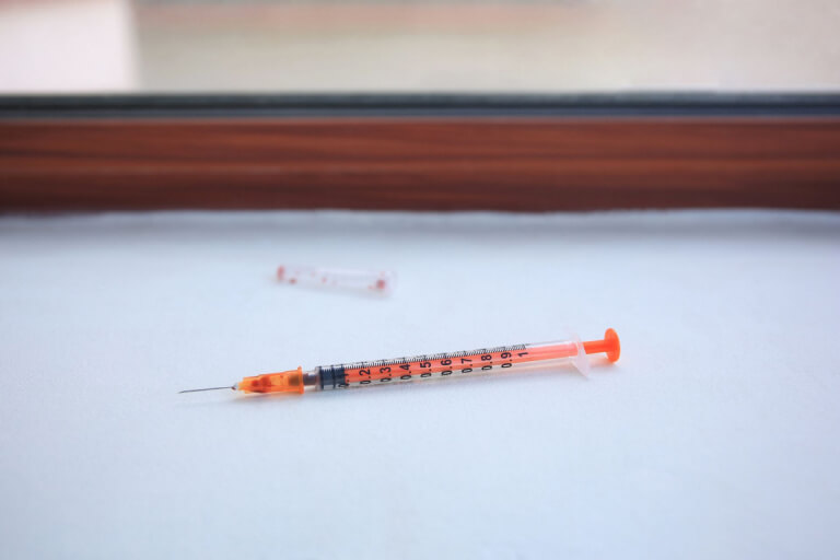 An empty syringe sits exposed on a table