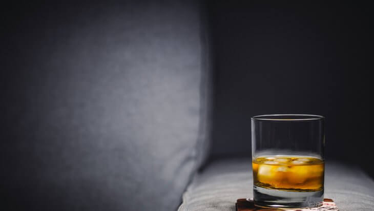 A glass of alcohol sitting on a coaster