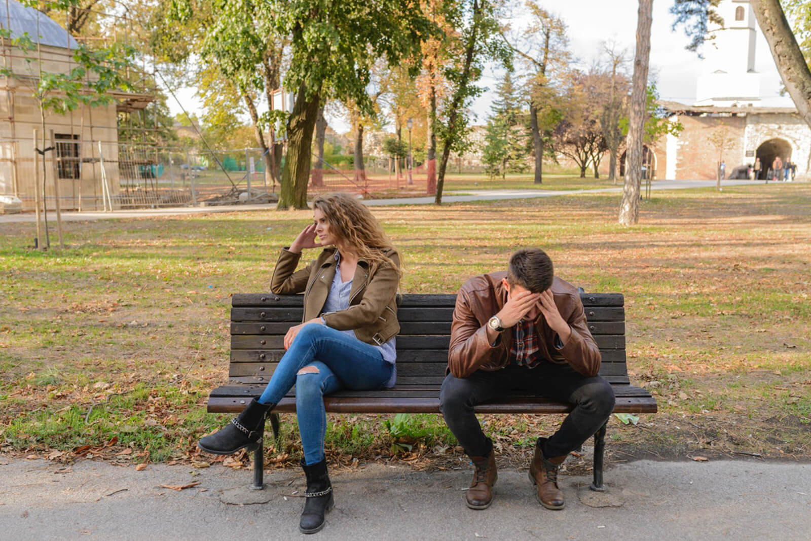 Couple fighting on a bench, turned away from each other