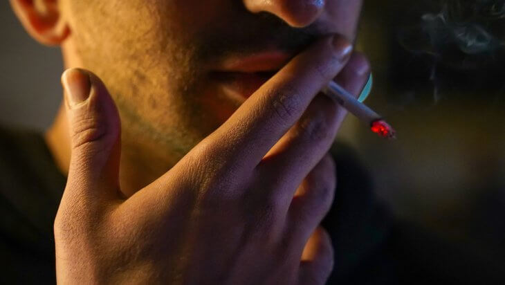 A close-up of a man smoking
