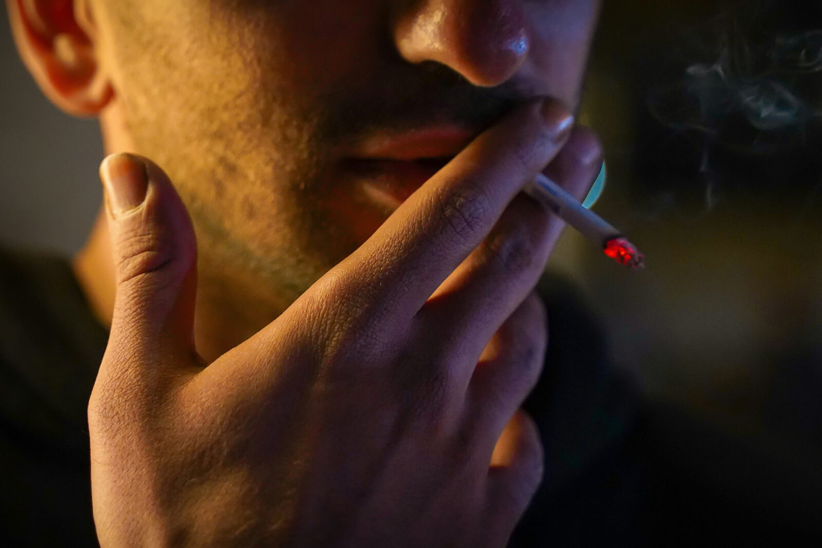A close-up of a man smoking