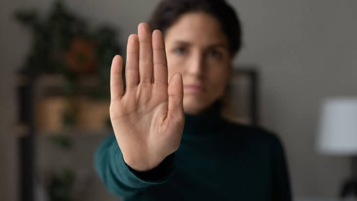 woman holds her hand up to say no to alcohol