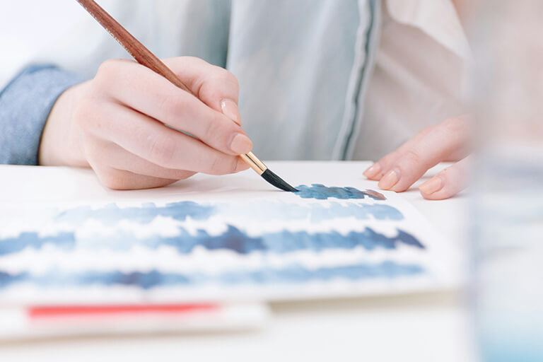 A person painting blue waves