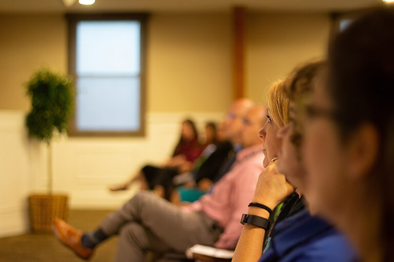 A group of people sitting and listening to a presentation