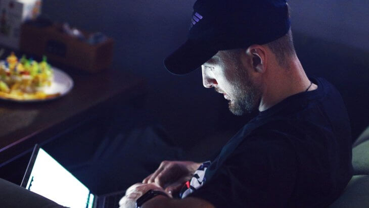 A man sitting in the dark using a laptop