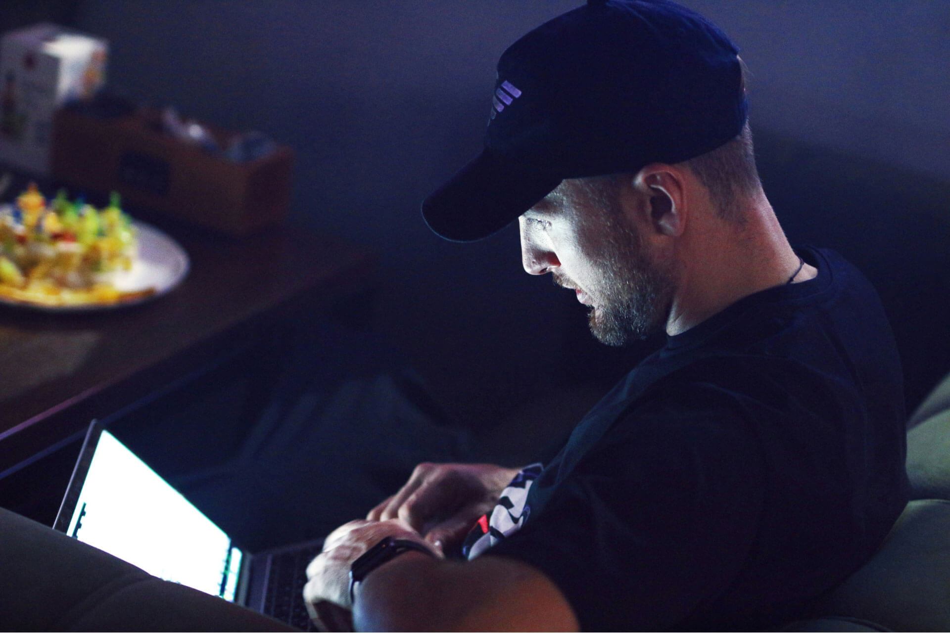 A man sitting in the dark using a laptop