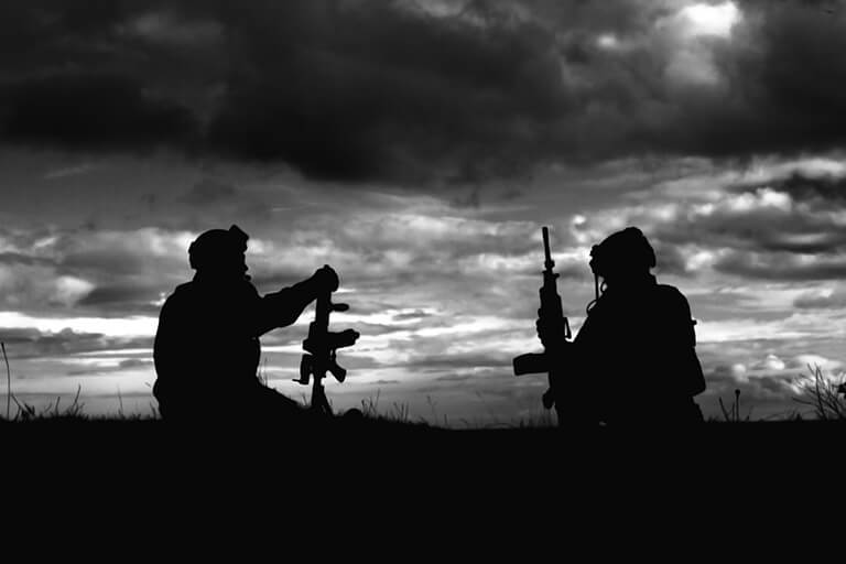 A black and white image of two soldiers in the battlefield holding high-power rifles