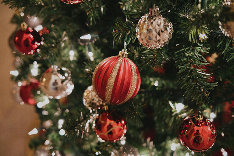 A close-up of red ornaments on a Christmas tree