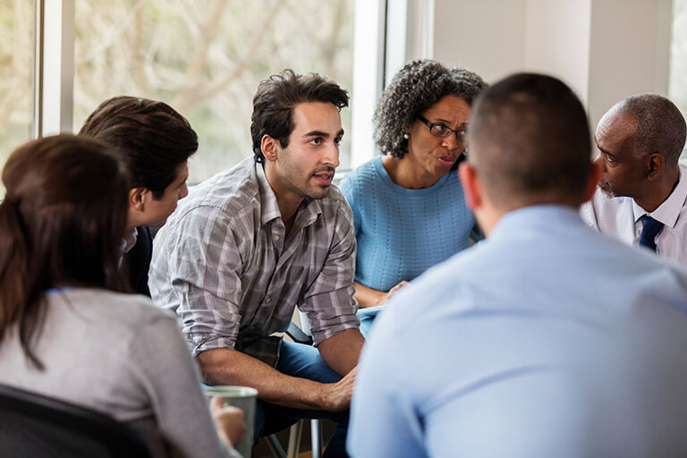 A person sharing their experience in a group therapy session