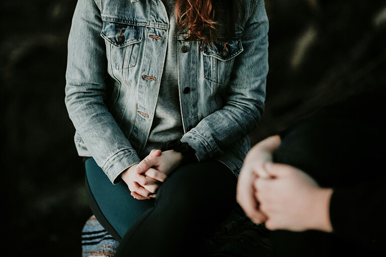 A woman sitting next to another person
