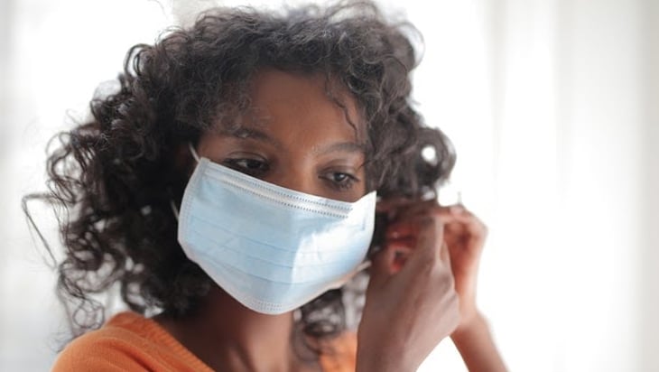 Woman putting on her face mask