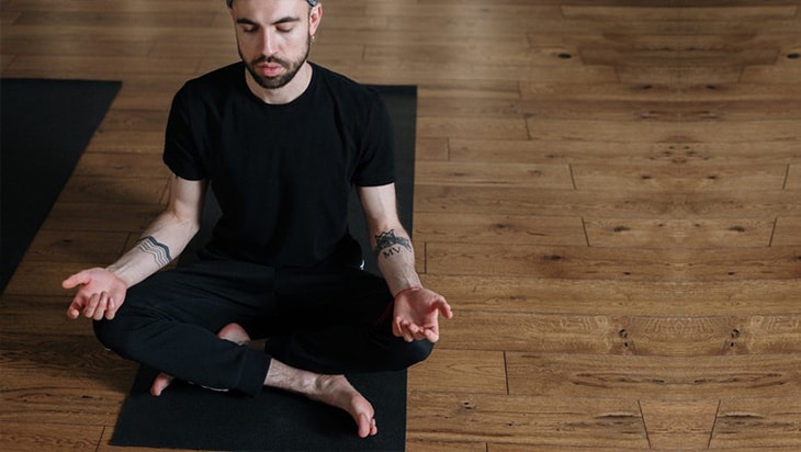 Man in black shirt and pants meditating